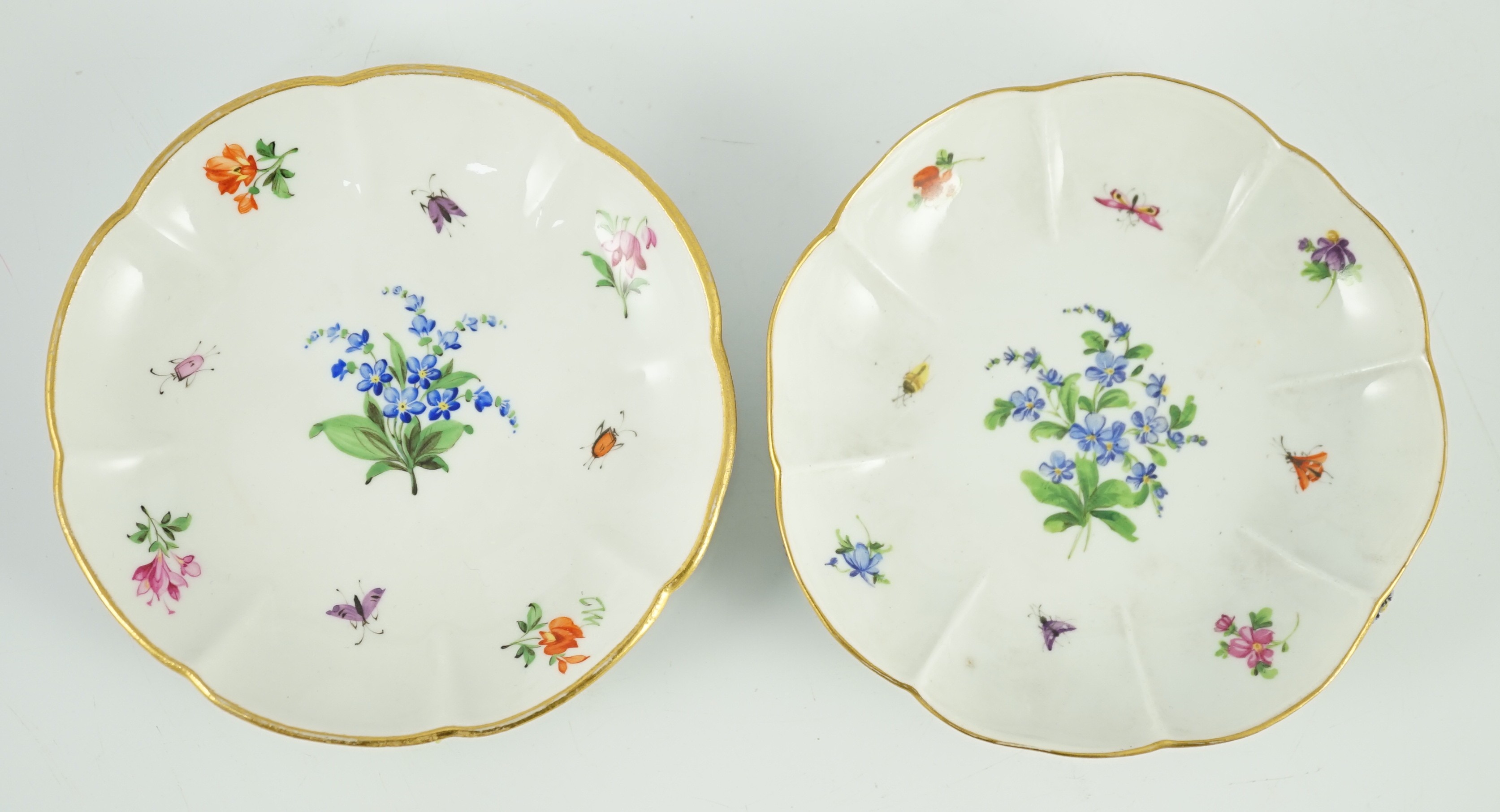 Two Meissen flower encrusted cups and saucers, 19th century, saucers 12cm wide, chips to flowers and leaves